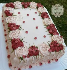 a large white and red cake with roses on it