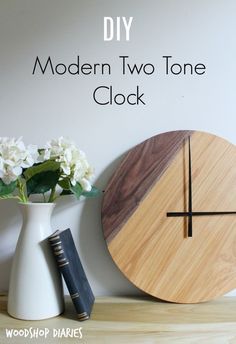 a wooden clock sitting on top of a table next to a vase with flowers