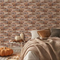 a bedroom with brick wallpaper and pumpkins on the floor in front of it