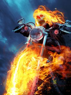 a man riding on the back of a motorcycle with flames in front of his face