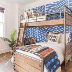 a bunk bed in a bedroom with blue and white wallpaper on the walls behind it