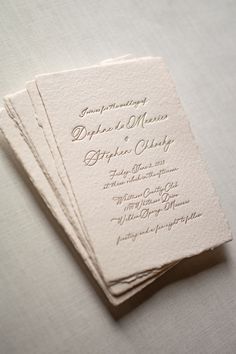 the wedding stationery is laid out on top of each other