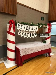 a table with a sign that says beverage station on it next to a red and white striped column