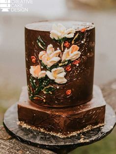 a chocolate cake decorated with flowers and leaves