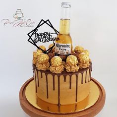 a cake with chocolate and caramel drizzled on it, topped with a bottle of beer