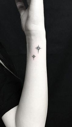 a woman's arm with a small star tattoo on it