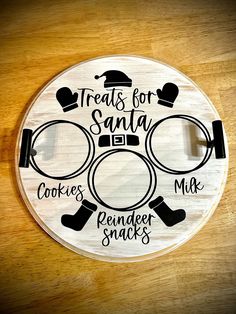 a white plate with black words on it that says treats for santa cookies, crackers, and more