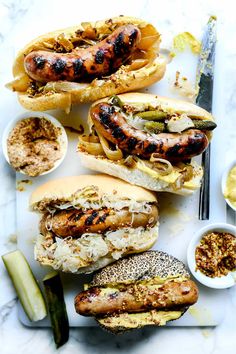 hot dogs and buns with pickles on the side