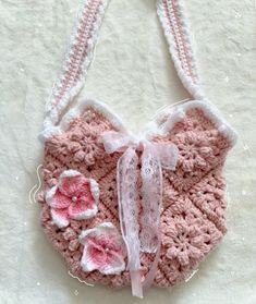 a pink crocheted heart with flowers on it