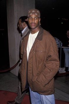 a man wearing a brown jacket and hat