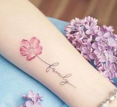 a woman's arm with flowers and the word family tattooed on her left forearm