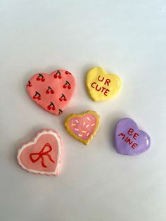 four heart shaped candies with the words our cute on them and hearts in different colors