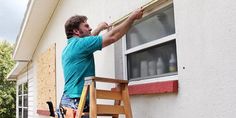 a man is painting the outside of a house