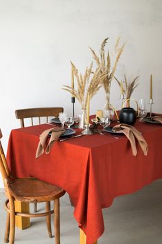 the table is covered with red cloths and place settings for two people to sit at