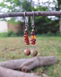 An earthy forest-inspired bohemian pair of silver dangle earrings; crafted with stainless steel French hooks, 4 mm polished unakite stone, brown sea glass, and a beautiful polished green unakite stone. *Handmade by me, one of a kind. *Length: 6 cm *Diameter of largest stone: 10 mm *Weight per Earring: 3 grams *Hook diameter: 1 mm *Crafted with silver stainless steel hypoallergenic hooks.  Nickel free. Click on the link below if you would like to see more artisan jewelry and unique artwork! https://www.etsy.com/shop/CailinCreatesCo I try my best to accurately portray the details in all of my jewelry. Please note that colors may vary due to lighting conditions, camera settings, and variations in computer monitor or phone display settings. If you have any questions regarding any items I have Nature-inspired Dangle Earrings, Handmade Adjustable Amber Earrings, Earthy Dangle Earrings With Ear Wire, Bohemian Amber Drop Earrings, Handmade Earthy Earrings For Festival, Adjustable Earthy Dangle Earrings, Earthy Handmade Earrings For Everyday Wear, Handmade Artisan Jewelry For Outdoor, Nature-inspired Hypoallergenic Dangle Earrings