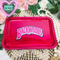 a tray with the word backwoods on it surrounded by flowers and other decorations