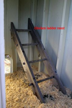 a ladder leaning up against the side of a building that is filled with sand and gravel