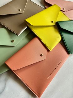 four different colored envelopes sitting on top of each other