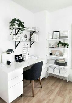 a white desk topped with a computer monitor next to a book shelf filled with books