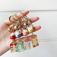 a person is holding several charms in their hand