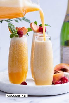 two glasses filled with fruit and juice being poured into them