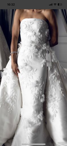 a woman in a white wedding dress is posing for the camera