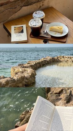 there is a book and some food on the table next to the water with rocks