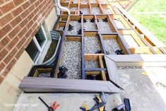 some tools are laying out on the ground next to a brick wall and window frame