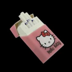 a pink hello kitty toothbrush holder on a black background