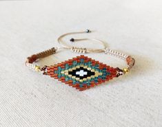 "A very special evil eye made of original miyuki seed beads. Of great detail, this bracelet also features 3 goldstone beads on each side of its macrame body and tiny crystal bead finishing. Miyuki eye size: 3.5 cm / 1.37 inch approx. Gold sand stone or Goldstone is meant to be a \"warrior crystal\" that guards against negative energy. Enhancing the positive vibes of the evil eye, makes this bracelet a very special and elegant lucky charm. Adjustable to fit all sizes. ♥ Comes via registered mail like all Tatiboo items. *Ready to dispatch upon clearance of payment, delivery time depends on your location. *No additional shipping fees if purchased with another item!" Resizable Evil Eye Bracelet With Round Beads For Festivals, Adjustable Bohemian Beaded Bracelets With Evil Eye, Bohemian Evil Eye Bracelet With Resizable Round Beads, Bohemian Beaded Bracelets For Jewelry Making With Evil Eye, Bohemian Friendship Bracelets With Evil Eye, Bohemian Evil Eye Beaded Bracelets For Jewelry Making, Bohemian Style Evil Eye Beaded Bracelet, Bohemian Evil Eye Bracelet With Round Tiny Beads, Resizable Evil Eye Bracelet With Round Beads