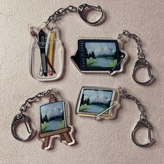 four different key chains with pictures and pens in them on a white surface, one is empty