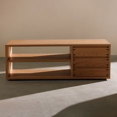 a wooden entertainment center with two drawers on each side and one drawer open to reveal something