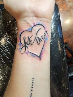 a woman's wrist tattoo with the word love written on it