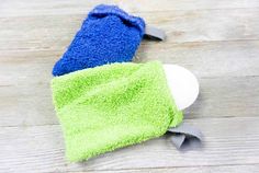 a blue and green towel laying on top of a wooden floor next to a pair of scissors