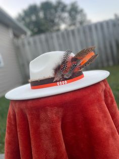 Customized off-white felt flat brimmed hat with feather, gold and real leather accents. One of a kind and perfect for fall! One size fits all with ability to tighten and loosen fit on inside of hat. White Adjustable Fedora With Flat Crown, Adjustable White Fedora With Flat Crown, White Flat Crown Fedora For Kentucky Derby, White Western Fedora With Flat Crown, Adjustable White Hat Band For Fall, White Flat Crown Hat For Rodeo, White Flat Brim Felt Hat For Fall, White Brimmed Fall Hat, Bohemian White Felt Hat With Flat Brim