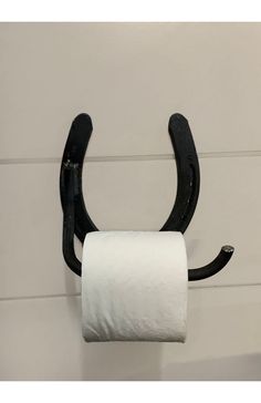 a white toilet paper roll hanging from a black hook