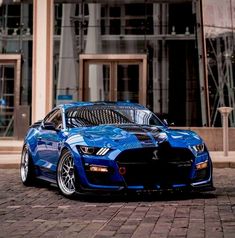 a blue sports car parked in front of a building