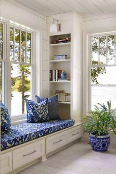 a blue and white window seat with pillows on it