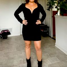 a woman standing in a room with her hands on her hips and wearing black boots