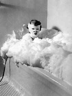 a woman is in the bathtub covered with foam