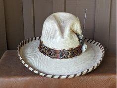 The popular Pheasant Hunt hat has returned decked out in a new hat body. This Gus palm hat from Guatemala is a golden oak color with a 4" brim and a 5 1/4" crown. It has a very comfortable cloth sweatband. Hand laced in a rustic brown leather lace, pheasant ribbons and more feathers. Check out the Venery Pheasant feather. Not all pheasants look the same. Finished with a deer antler rosette. All hats are made to order. Allow up to 4 weeks for your hat to ship. Natural Toquilla Straw Hat With High Crown, Natural Color Hat With Short Brim For Western-themed Events, Southern Style Brown Hat With Curved Brim, Natural Short Brim Hat For Western-themed Events, Kentucky Derby Toquilla Straw Hat For Western-themed Events, Brown High Crown Hat For Kentucky Derby, Traditional Fedora Hat For Rodeo, Traditional Brown Hat For Rodeo, Traditional Hats With Short Brim For Western-themed Events