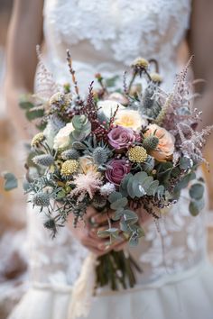 a bridal holding a bouquet of flowers and greenery