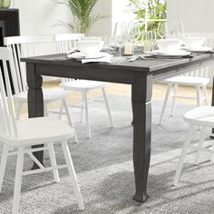 a dining room table with white chairs around it