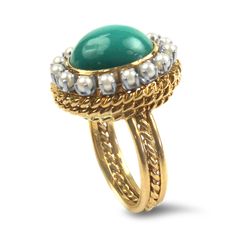 This stunning 14K yellow gold turquoise and pearl ring showcases a captivating 12x10x5.5mm turquoise cabochon, elegantly bezel set at its center. Surrounding the vibrant turquoise are 15 exquisite 2mm prong-set seed pearls, adding a touch of elegance and sophistication. The ring features intricate rope detailing around both the head and shank, enhancing its unique design. The polished shank measures 3.8mm, providing a comfortable fit while maintaining durability. Perfect for any occasion, this ring is a beautiful blend of color and classic craftsmanship, tested and confirmed at 14k for authenticity.Replacement Value: $1,925.00 Elegant Gold Turquoise Cabochon Ring, Vintage Yellow Gold Turquoise Cabochon Ring, Classic Yellow Gold Turquoise Cabochon Ring, Luxury Vintage Cabochon Turquoise Ring, Luxury Yellow Gold Turquoise Ring, Oval Cabochon, Seed Pearl, Ruby Ring, Pearl Ring, Bezel Setting