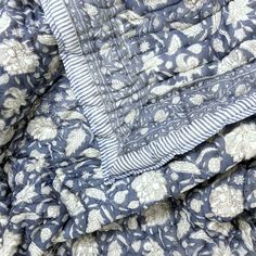 a blue and white quilted blanket with flowers on it