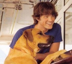 a man sitting with his dog on the floor