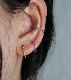 a woman's ear with three different colored bars on it, and one is in the middle