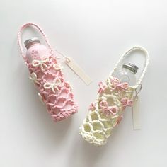 two crocheted shoes with tags attached to them on a white surface next to each other