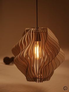 a light that is sitting on top of a table next to a lamp shade with wavy lines