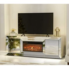 an entertainment center with a fireplace and christmas tree in the corner, next to a white couch